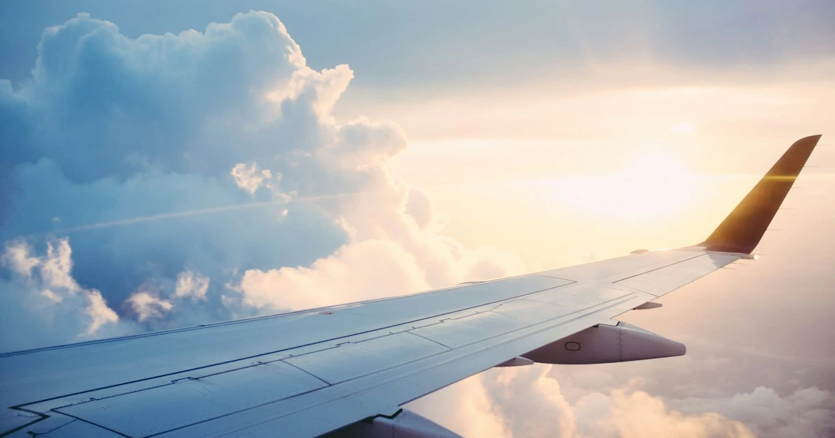 Avión despegando sobre la pista de un aeropuerto al atardecer, símbolo de viajes internacionales para colombianos